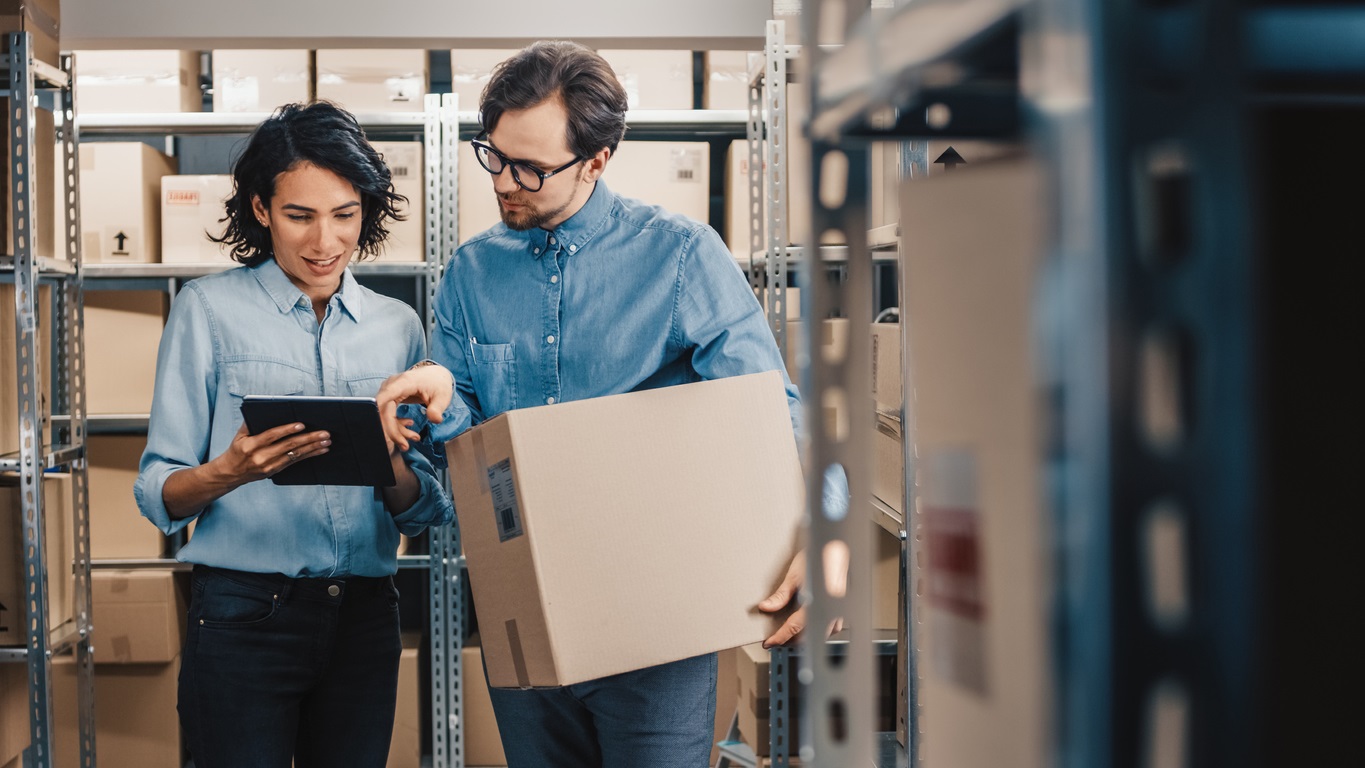 Inventory Manager Shows Digital Tablet Information to a Worker Holding Cardboard Box