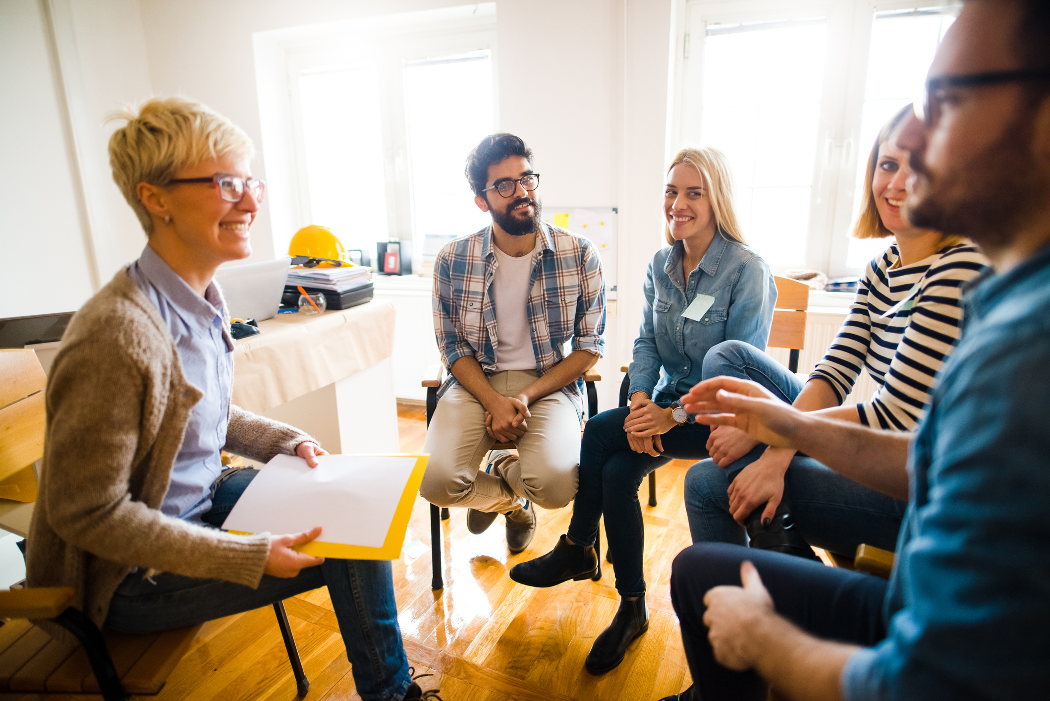 Group of people sitting in a circle at group therapy