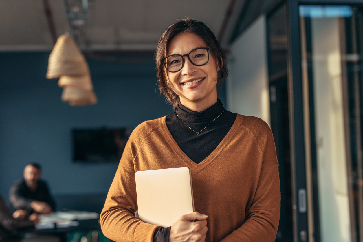Smiling woman holding a laptop